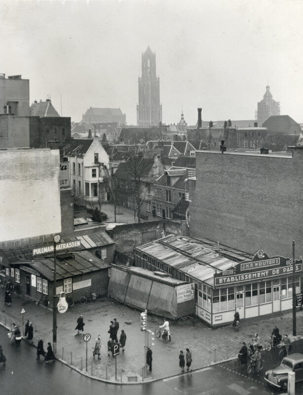 De hoek van het Vredenburg en de Lange Viestraat in 1952 met de poffertjeskraam Etablissement De Paris van J.H.R. Wouters, de nougatkraam en het kantoortje van de VVV, kort voor de bouw van het Hotel Smits. Foto: L.H Hofland/HUA