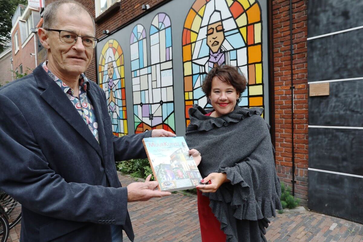 Joost van Waert overhandigt zijn Muurkunst aan burgemeester Sharon Dijksma. Foto: Ton van den Berg