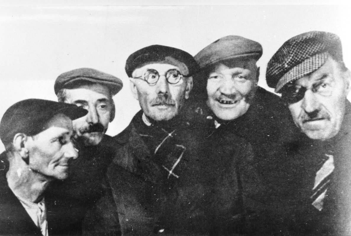 Groepsportret van vijf bewoners uit Wijk C te Utrecht, die allen een bijnaam hebben, v.l.n.r.: Louis Bronius ('De Sponzenduiker'), de heer Bontrop ('De Kruk' ?), Jacobus Broekman ('Kobus de Fots'), Johannes van den Oudenalder ('Hannes de Kokkel') en Piet