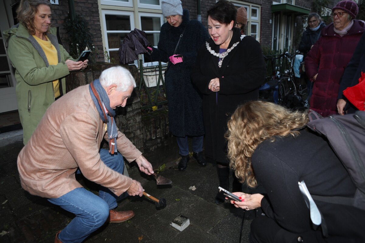 Kleinzoon Charles Chamboné plaatst, onder toezicht van burgemeester Sharon Dijksma, de stolperstein. Foto: Ton van den Berg