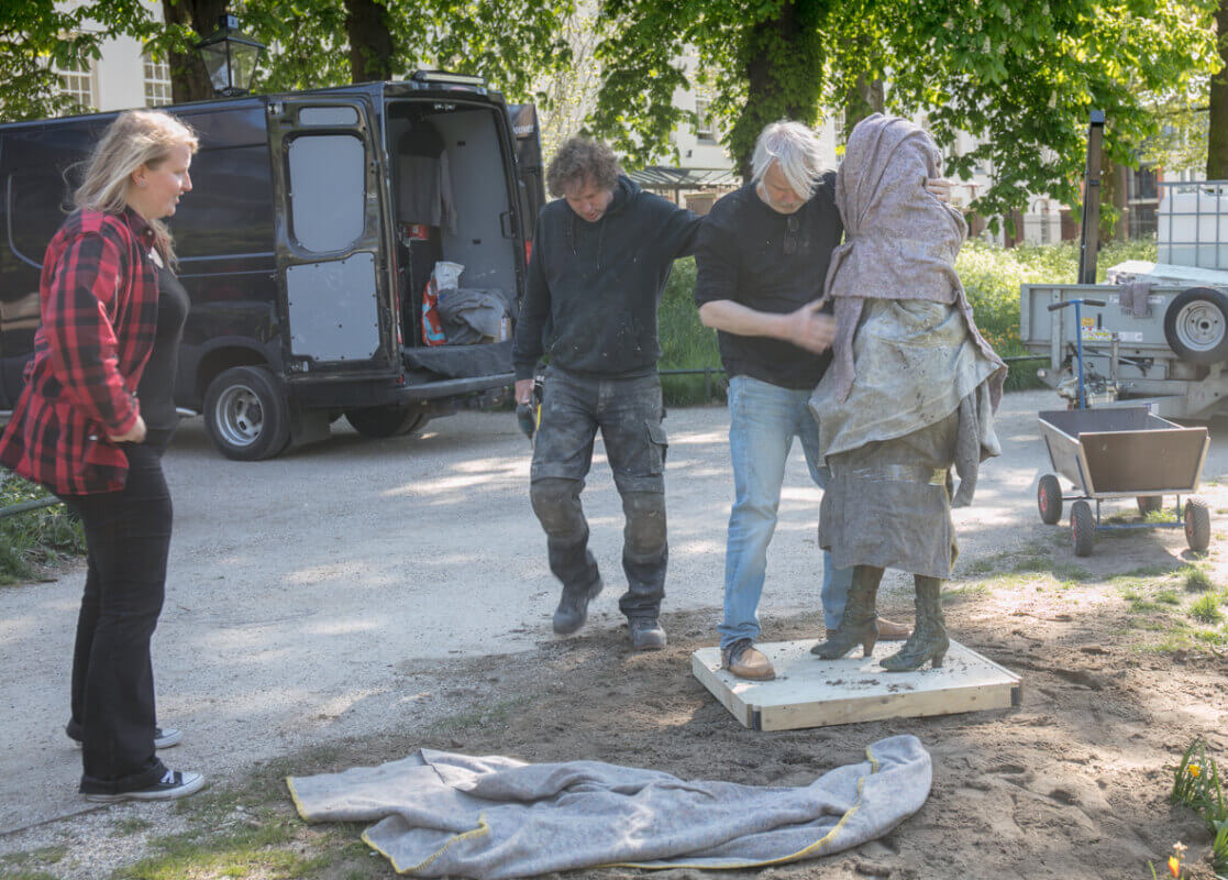 Joyce Overheul kijkt toe hoe het beeld van Truus van Lier wordt geplaatst. Foto: Binnenstadskrant