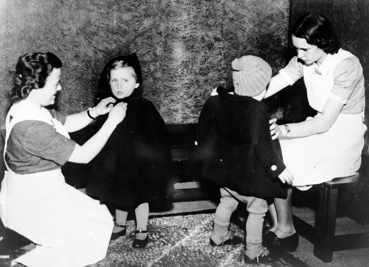 Trui van Lier (links) en Jet Berdenis van Berlekom helpen twee kinderen in hun jas. (Foto HUA)