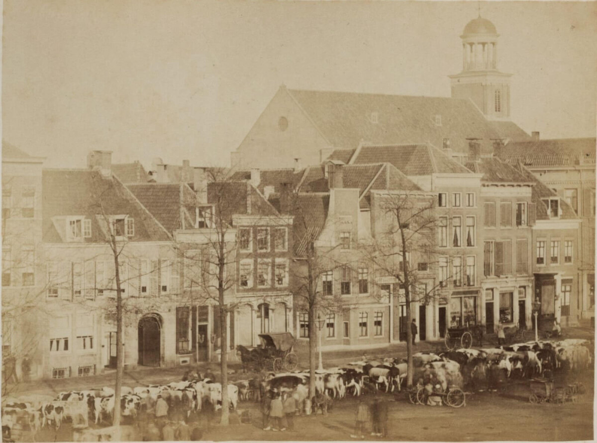 Een oude foto van de noordzijde van het Vreeburg per omstreeks 1876. Zo zag het er dus uit toen A.A. van de Bilt al wel beide panden in bezit had, maar nog niet had samengevoegd. Ter verduidelijking, het gaat dus om de twee panden rechts naast de Hoogenbergsteeg, waarvan we de ingang direct achter de boerenkar zien. (HUA122231)