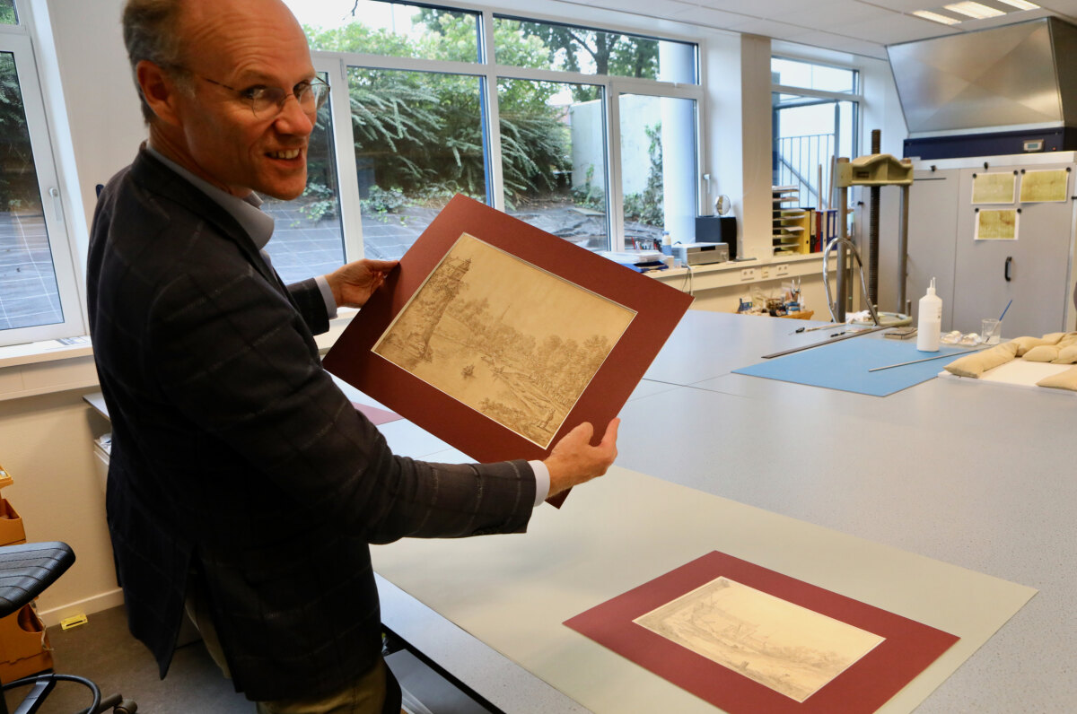Rijksarchivaris Kaj van Vliet met de tekeningen van Herman en Cornelis Saftleven. Foto: Ton van den Berg