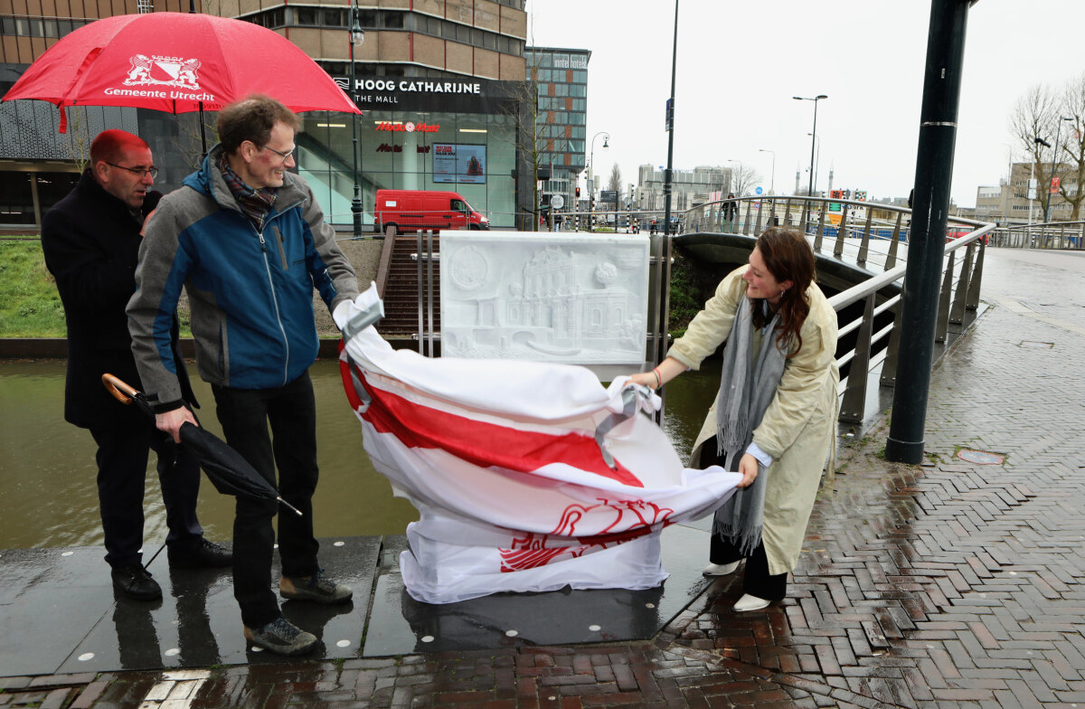Toon Rijkers (links) en wethouder Eva Oosters onthullen de plaquette op de Catharijnebrug. Foto: Ton van den Berg