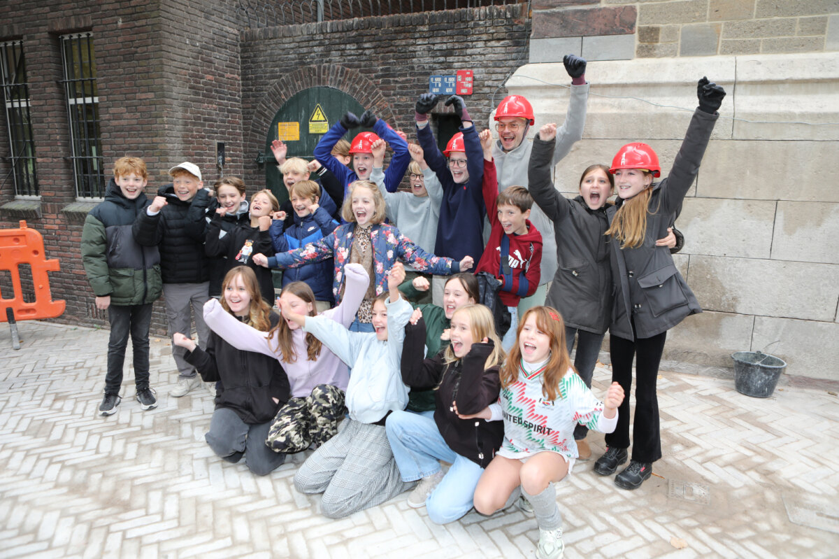 Wethouder De Vries en kinderen van de Pieterskerkhofschool bij de Domtoren. Foto: Ton van den Berg