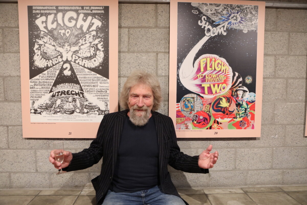 Kunstenaar Jan de Haas met links van hem de door hem ontworpen poster van de Flight in 1967 (rechts de poster van 1968 van Arne Zuidhoek). Foto: Ton van den Berg