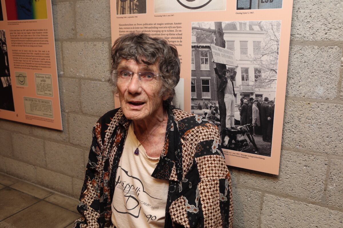 Oud-PSP-raadslid Rob van Gemert naast een foto van hem uit de jaren '60 bij een anti-oorlogsdemonstratie. Foto: Ton van den Berg