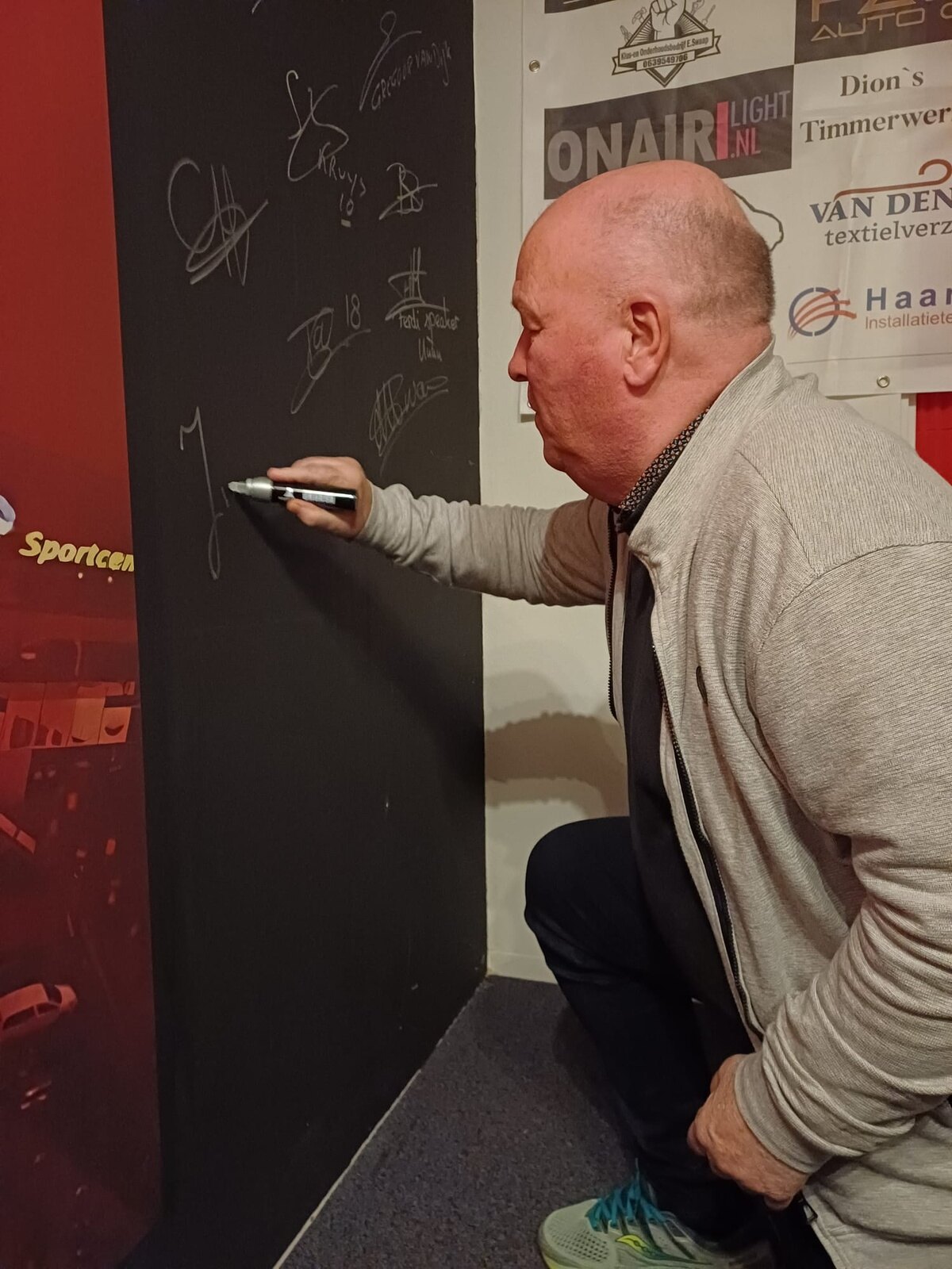 Koos van Tamelen zet zijn handtekening in de studio van Zondag is Ons Daggie. Foto: E. van der Zouw