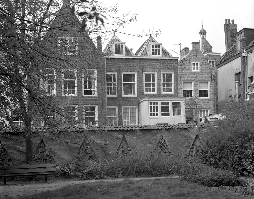 Flora's Hof met uitzicht op huizen aan de Lichte Gaard, langs de muur timpanen uit het pandhof van de Domkerk. Foto HUA
