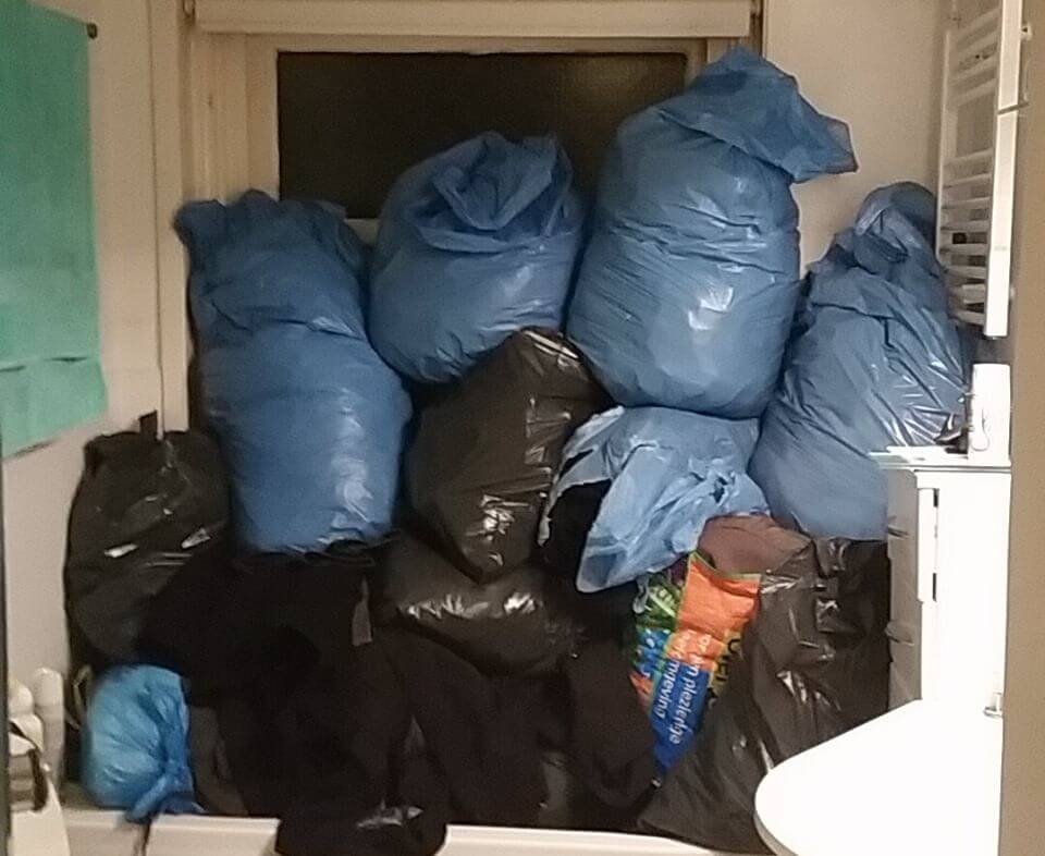 De kledingzakken liggen opgestapeld. Foto: C. Koldenhove