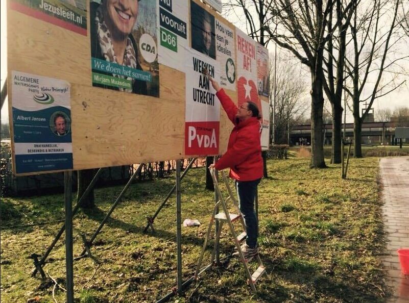 PvdA'er Annet Krijgsman plakt op een verkiezingsbord. Foto: PvdA-Provincaiel Staten Utrecht