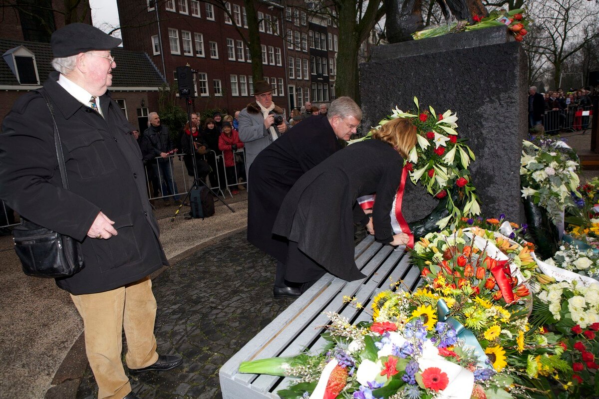 Ger Hoogenberg kijkt toe hoe burgemeester van Zanen en raadslid Scholten een krans leggen bij de Dokwerker. Foto: Ton van den Berg
