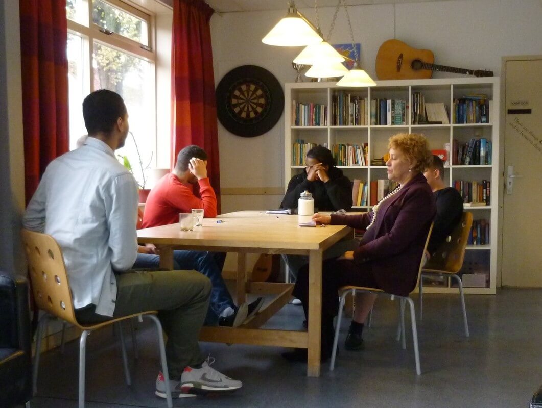 De huiskamer van Exodus Utrecht met rechts groepsbegeleider Carla Smit. Foto: Jan Jansen