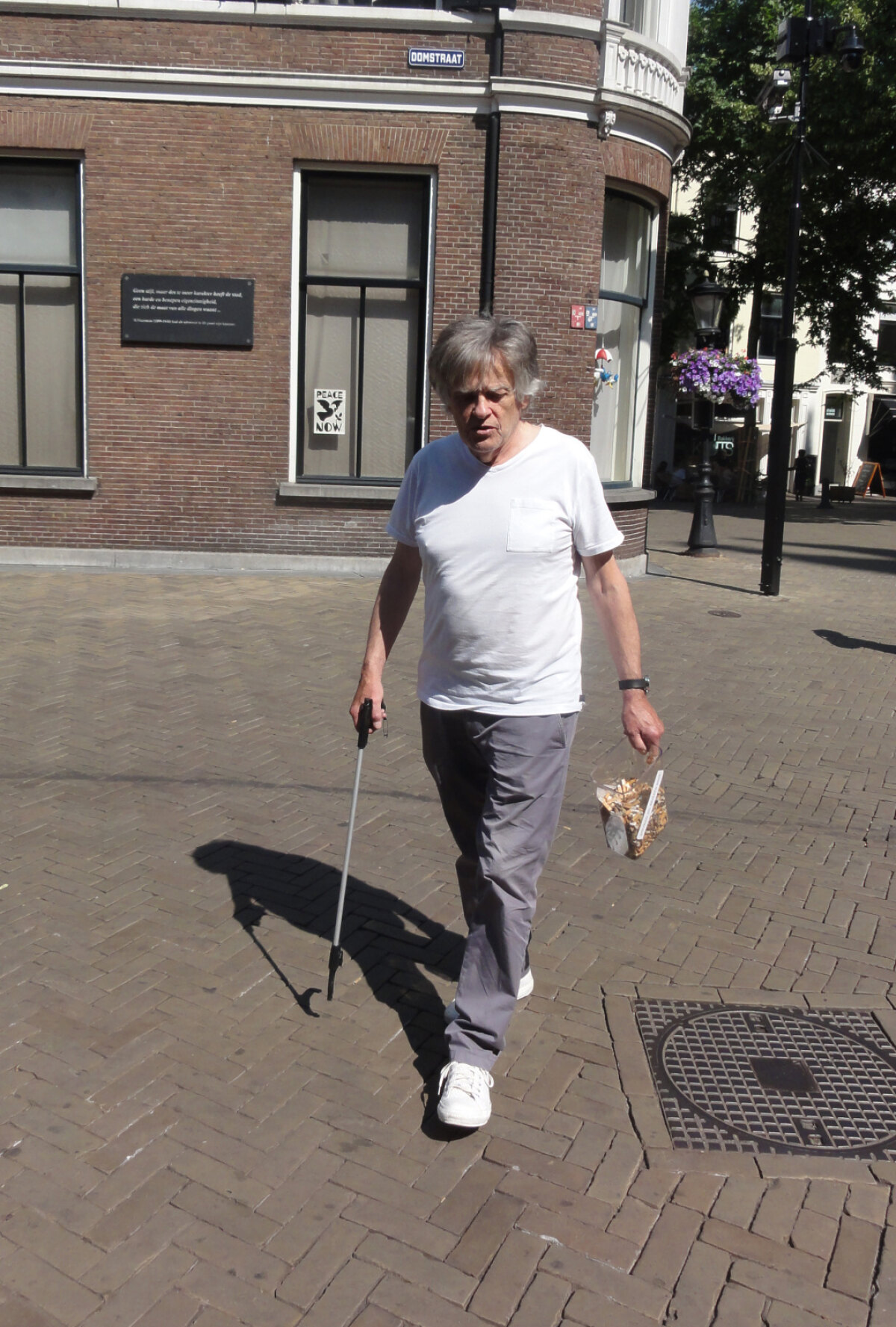 Binnenstadsbewoner Sjaak Ramakers tijdens het peukenrapen