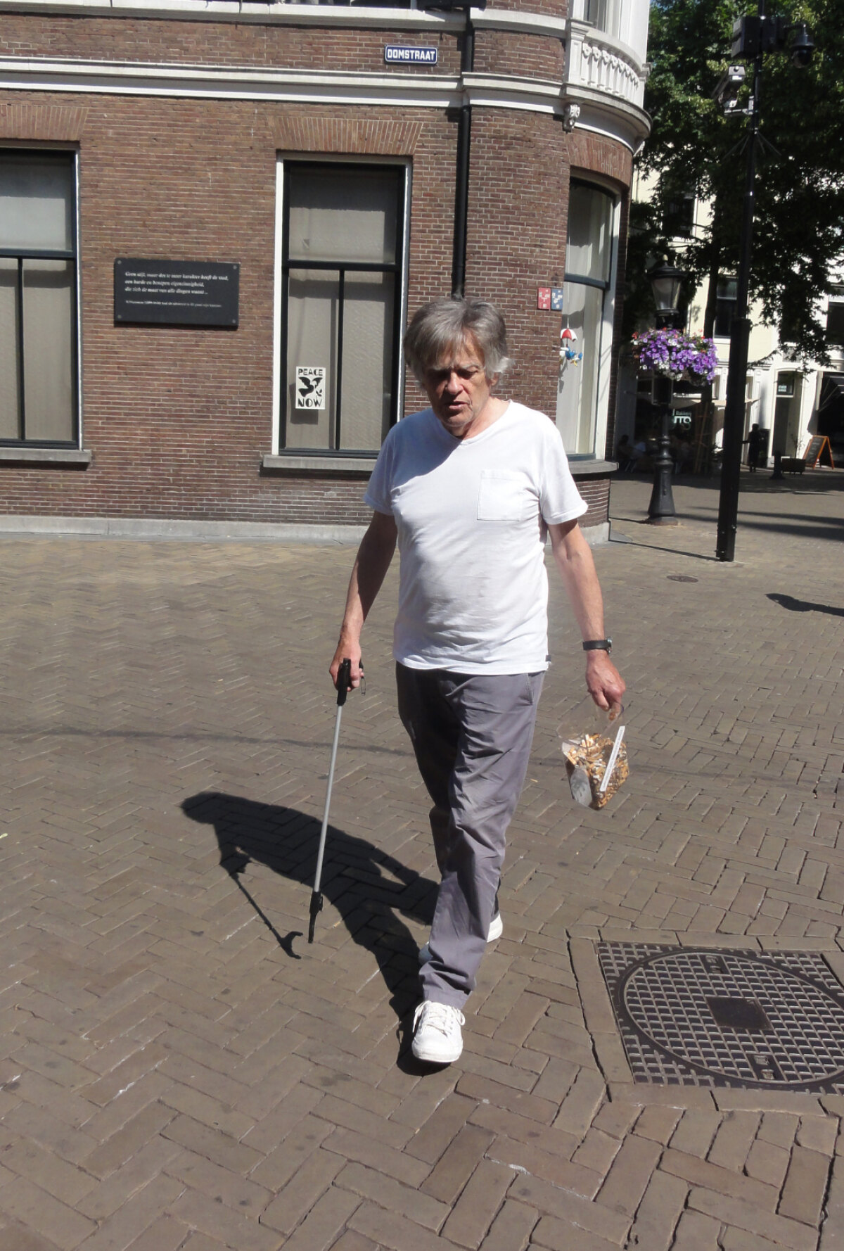 Binnenstadsbewoner Sjaak Ramakers tijdens het peukenrapen