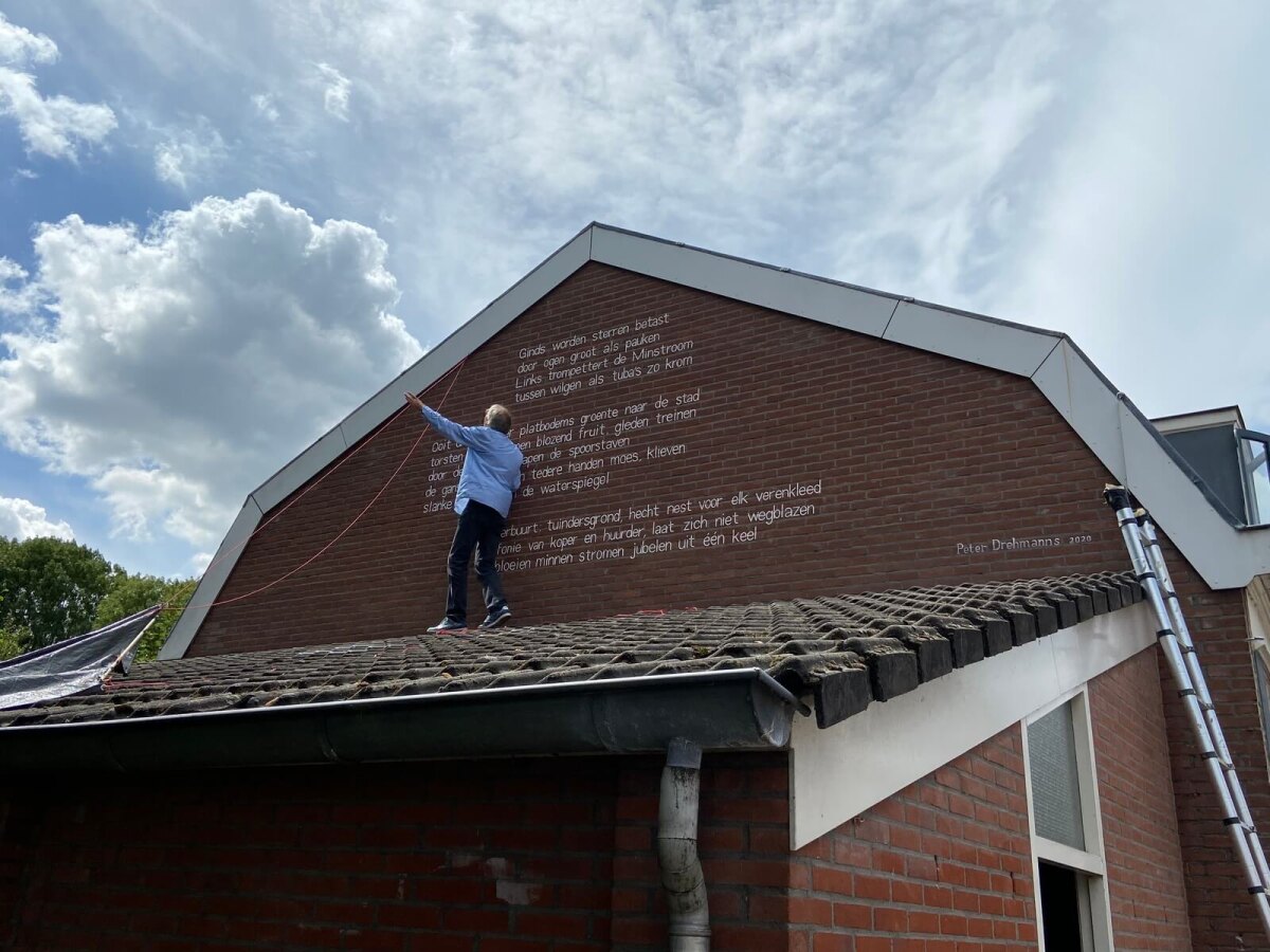 De man die de letters aanbracht, Jos Peeters, haalde na de onthulling de touwen weg. Foto; Jim Terlingen
