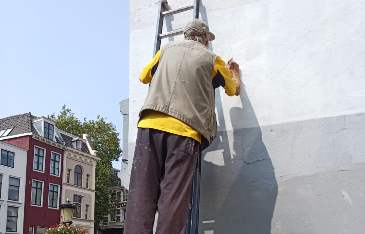 Muurschilder Jos Peeters zette het gedicht opnieuw op deze muur. Foto: MvD