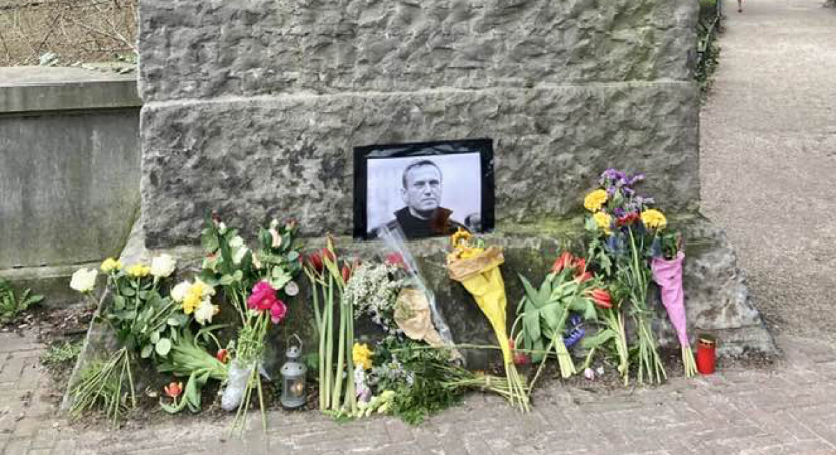 Bloemen bij het monument op de Bijlhouwersbrug. Detail van een foto van EW