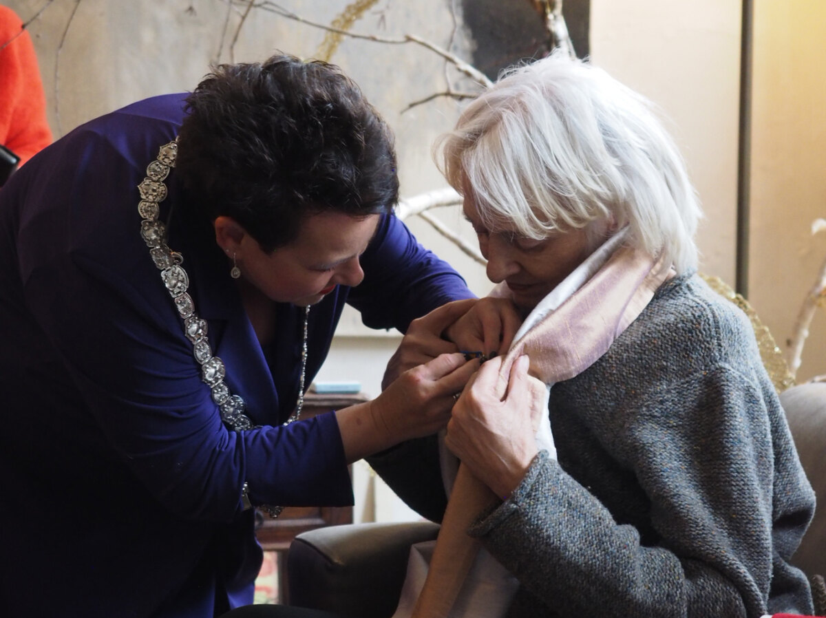 De burgemeester spelt Esther Jansma de ridderorde op. Foto: Josja Sanderink