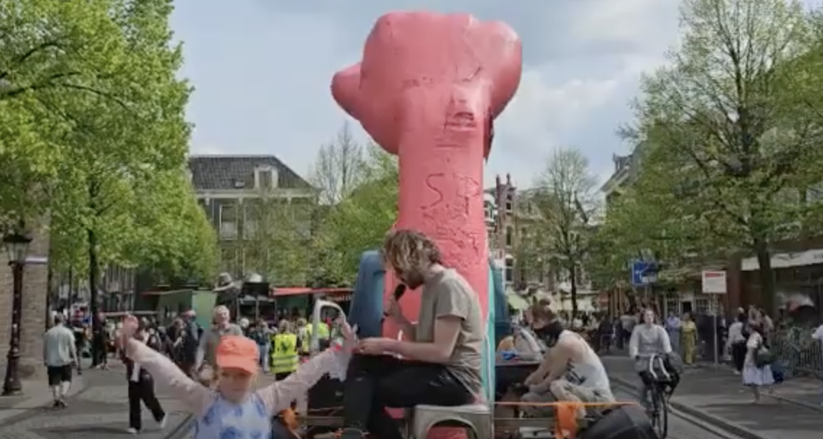 In 2023 zat Raymond Taams op een aanhangwagen naast een reusachtige roze vuist van piepschuim (still youtube)