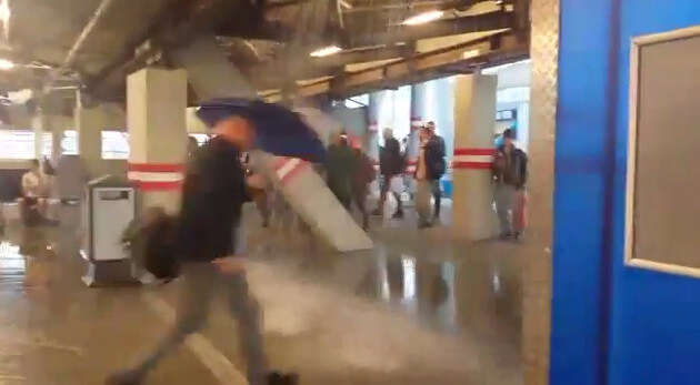 Met een paraplu door het Centraal Station.