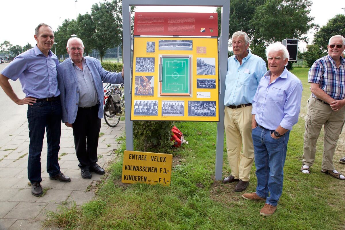 Wethouder Paulus Jansen (links) en Velox-speler Theus Huygens (met handen in de zak) mochten het informatiebord over Velox onthullen. Foto: Ton van den Berg
