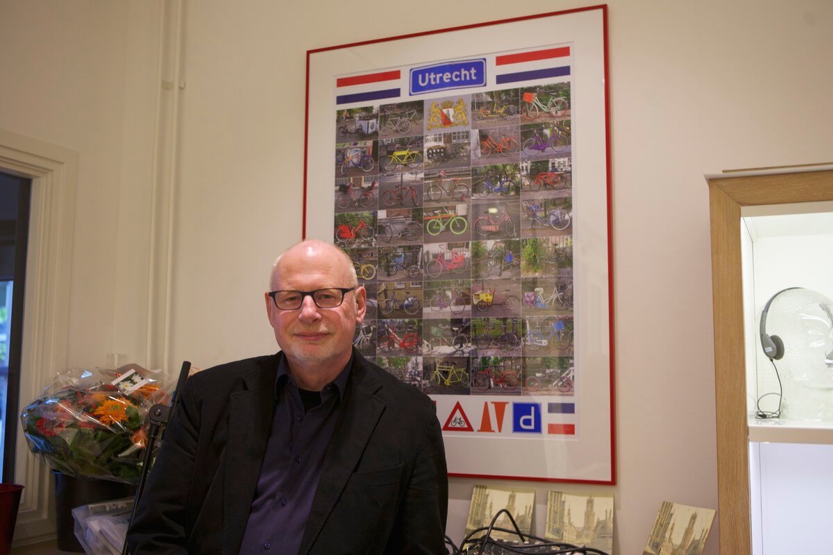 Martin Minjon met achter hem zijn Utrechtse fietsposter. Foto: Ton van den Berg