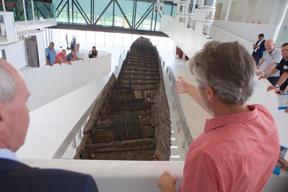 Erik Graafstal wijst op de kajuitwanden in het Romeinse schip De Meern 1. Foto: Ton van den Berg