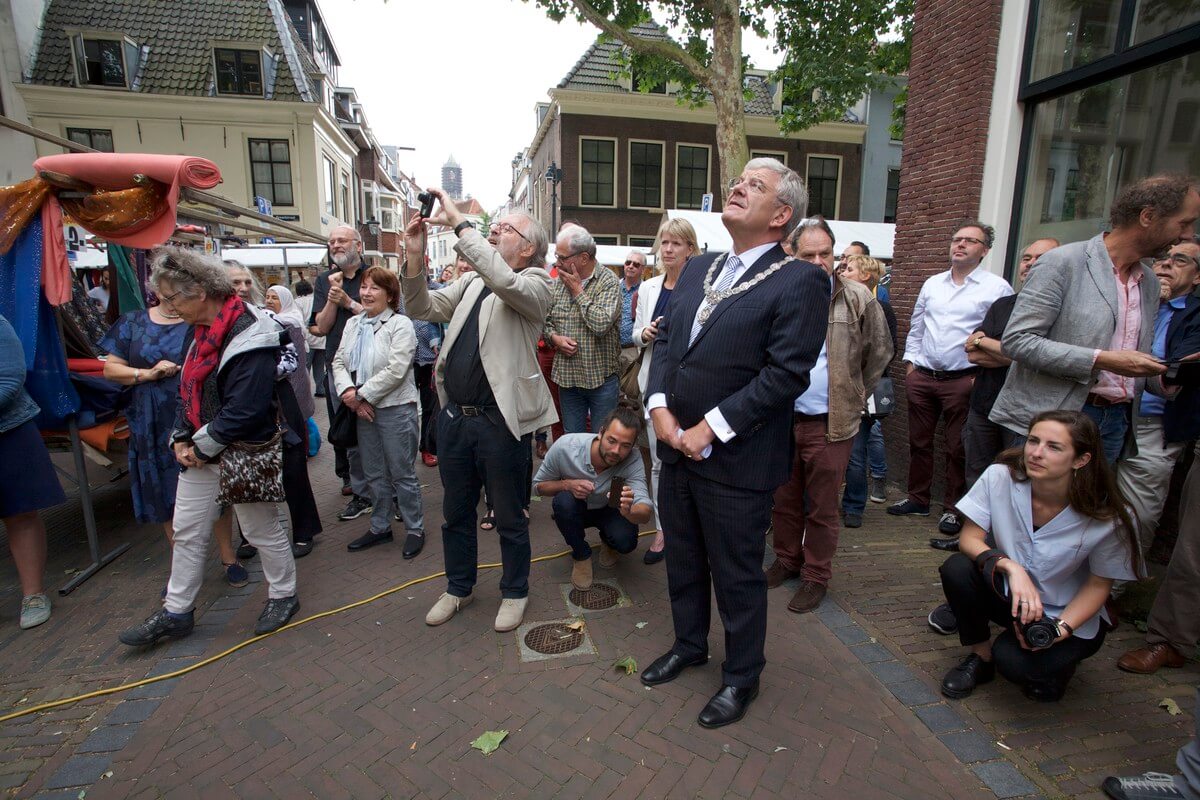 Bewoners en burgemeester bewonderen de muurtekst. Foto: Ton van den Berg