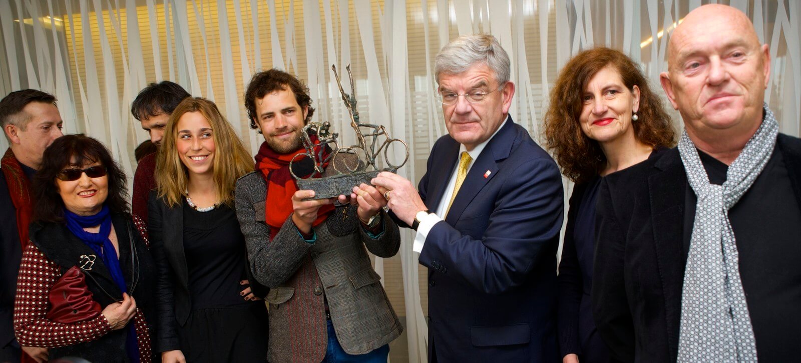 Burgemeester van Zanen met het schaalmodel van De Tourrenners in gezelschap van de familie Bakker en bestuursleden van Jits Art Museum Beelden. Foto: Ton van den Berg