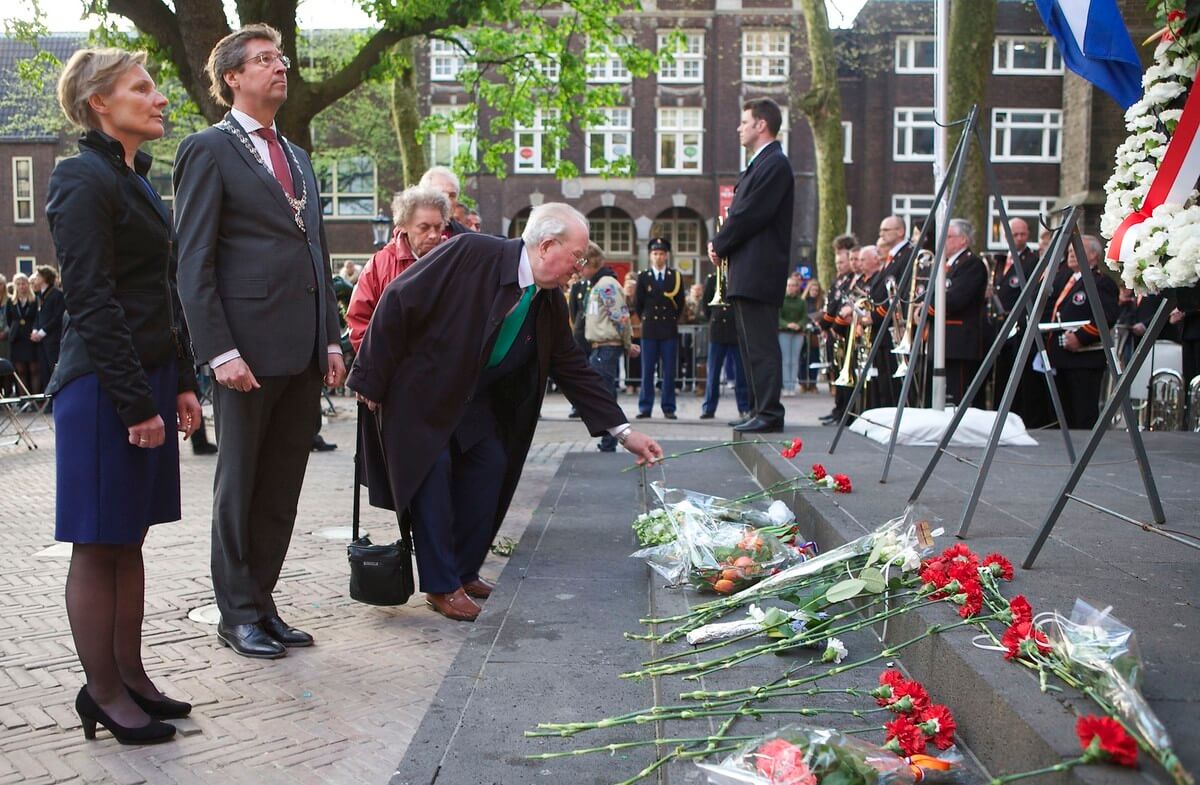 Ger Hoogenberg bij de dodenherdenking op het Domplein in 2013 legt een bloem (links van hem de toenmalige burgemeester Wolfsen). Foto: Ton van den Berg