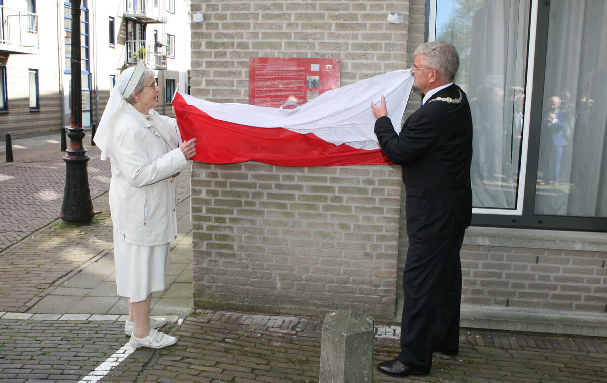 De onthulling van de plaquette met tekst over de gevelsteen De Duif. Foto: Ton van den Berg