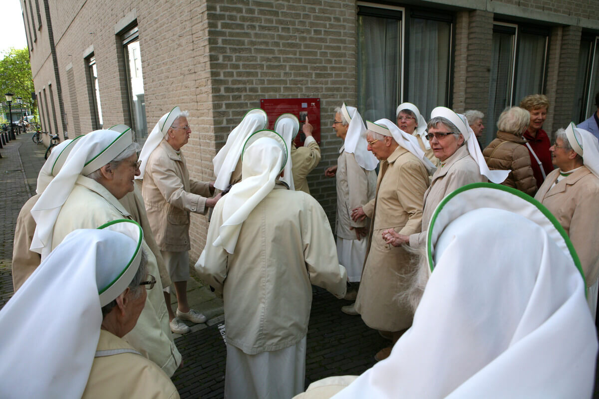 De zusters Augustinessen verdringen zich om de plaquette te kunnen bekijken. Foto: Ton van den Berg
