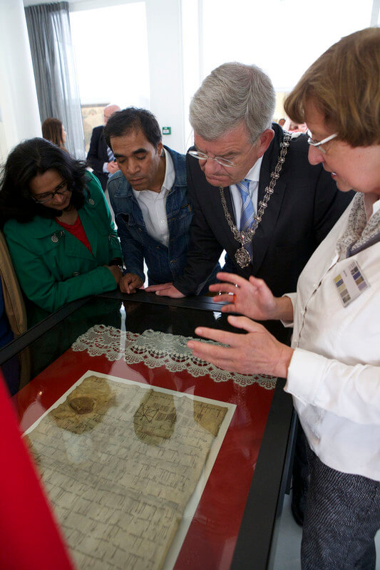 Burgemeester Van Zanen en andere nieuwsgierigen krijgen in 2014 tekst en uitleg bij het kalfsleren Stadsrecht. Foto: Ton van den Berg