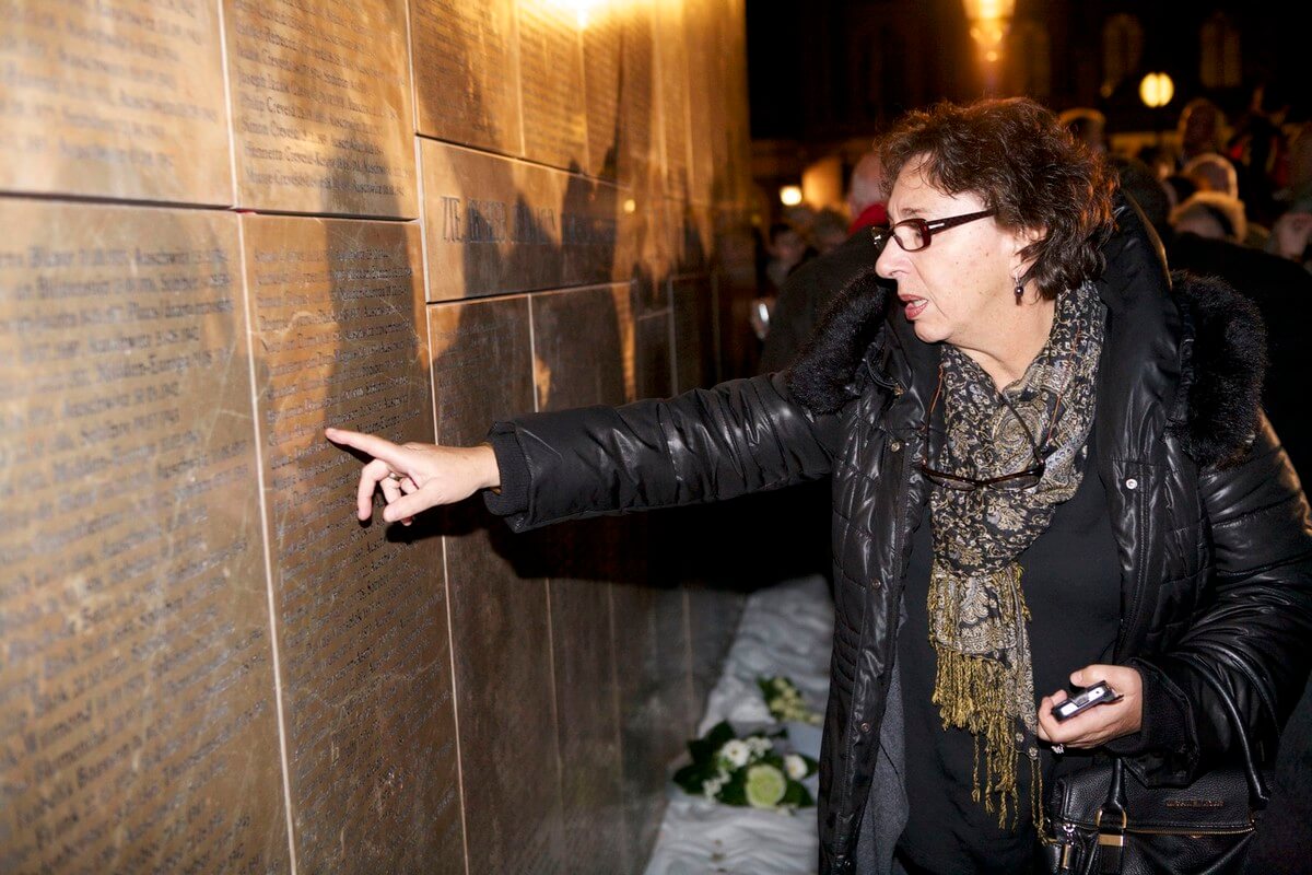 Een vrouw zoekt naar de namen op het Joods Monument. Foto: Ton van den Berg