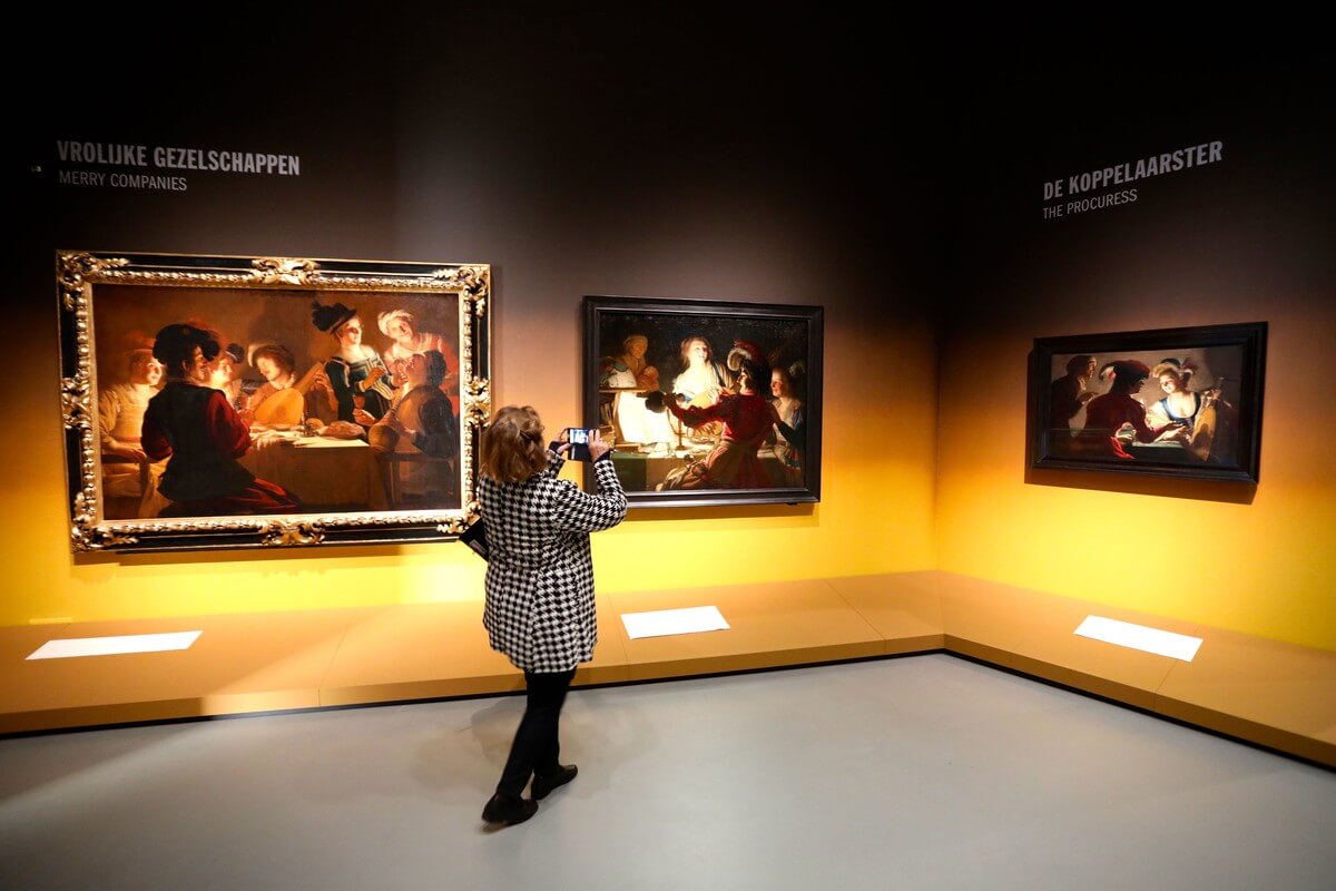 Hoekje met drie schilderijen waaronder rechts 'de koppelaarster' van Gerard van Honthorst. Foto: Ton van den Berg