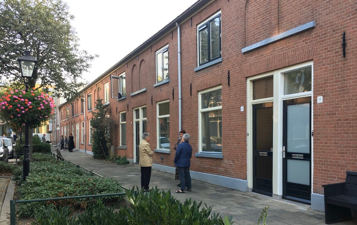 Buurtbewoners wachten op het langsrijden van de lijkwagen. Foto: Dik Binnendijk