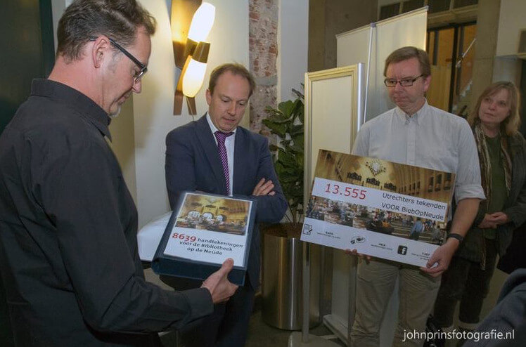 Initiatiefnemers van Bieb op de Neude overhandigen handtekeningen aan wethouder Kreijkamp. Foto: John Prins