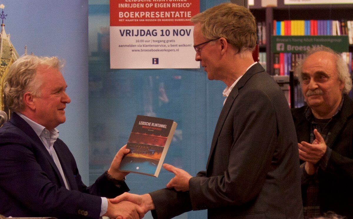 Journalist Kees Boonman reikt het eerste exemplaar uit aan auteur Miro Lucassen. Rechts Arjeh Kalmann van de stichting Spitwerk. Foto: Ton van den Berg
