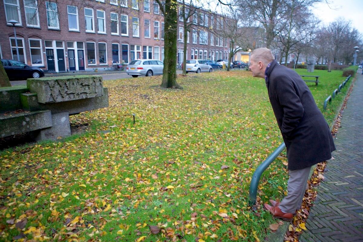 Wethouder Diepeveen bekijkt het beeld Zitplastiek op de Willem Arntszkade. Foto: Ton van den Berg
