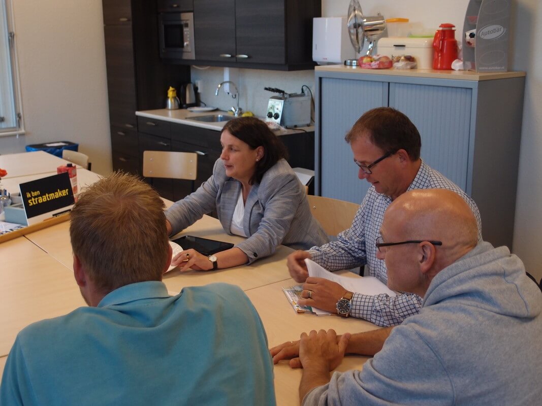 Wethouder Margriet Jongerius, met rechts van haar schooldirecteur John van Batenburg, in gesprek over een begeleidingstraject op het schoolplein van De Piramide. Foto: L. Engelman