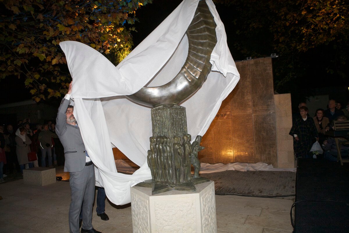Amiran Djanashvili trekt het doek weg van het Joods Monument. Foto: Ton van den Berg