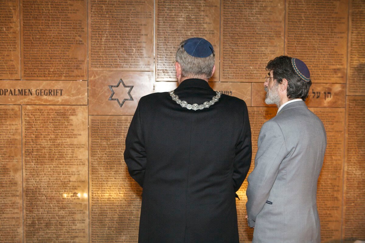 Burgemeester Van Zanen en Amiran Djanashvili bij de muur met meer dan 1200 namen van vermoorde Utrechtse joodse burgers. Foto: Ton van den Berg