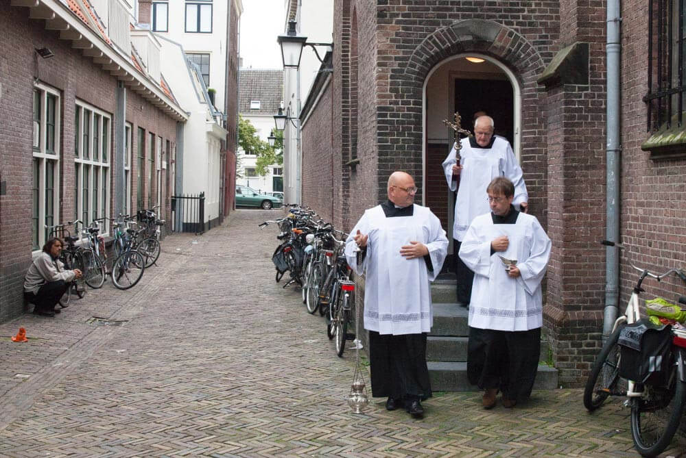 De acolieten lopen via de Catharijnesteeg naar de ingang van de kerk. Foto: Desiree Meulemans