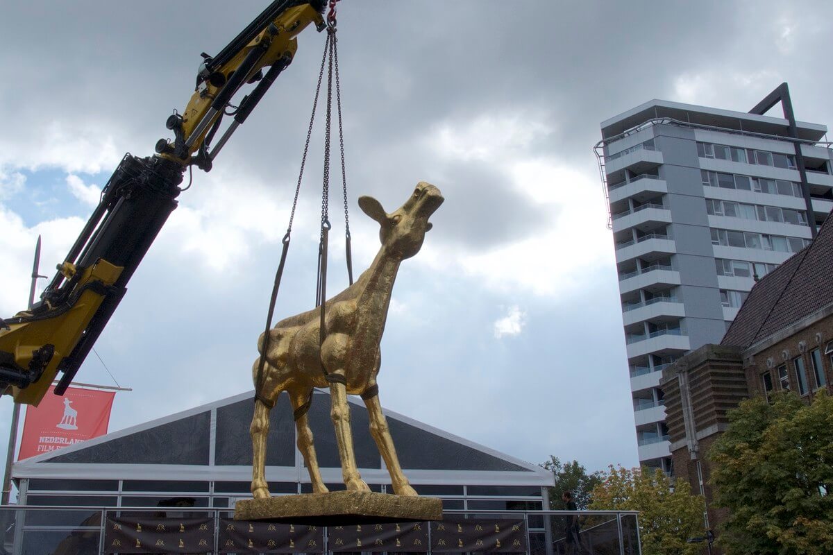 Het beeld Het Gouden Kalf van Theo Mackaay hangt in de lucht om op de Neude een plek te krijgen. Foto: Ton van den Berg