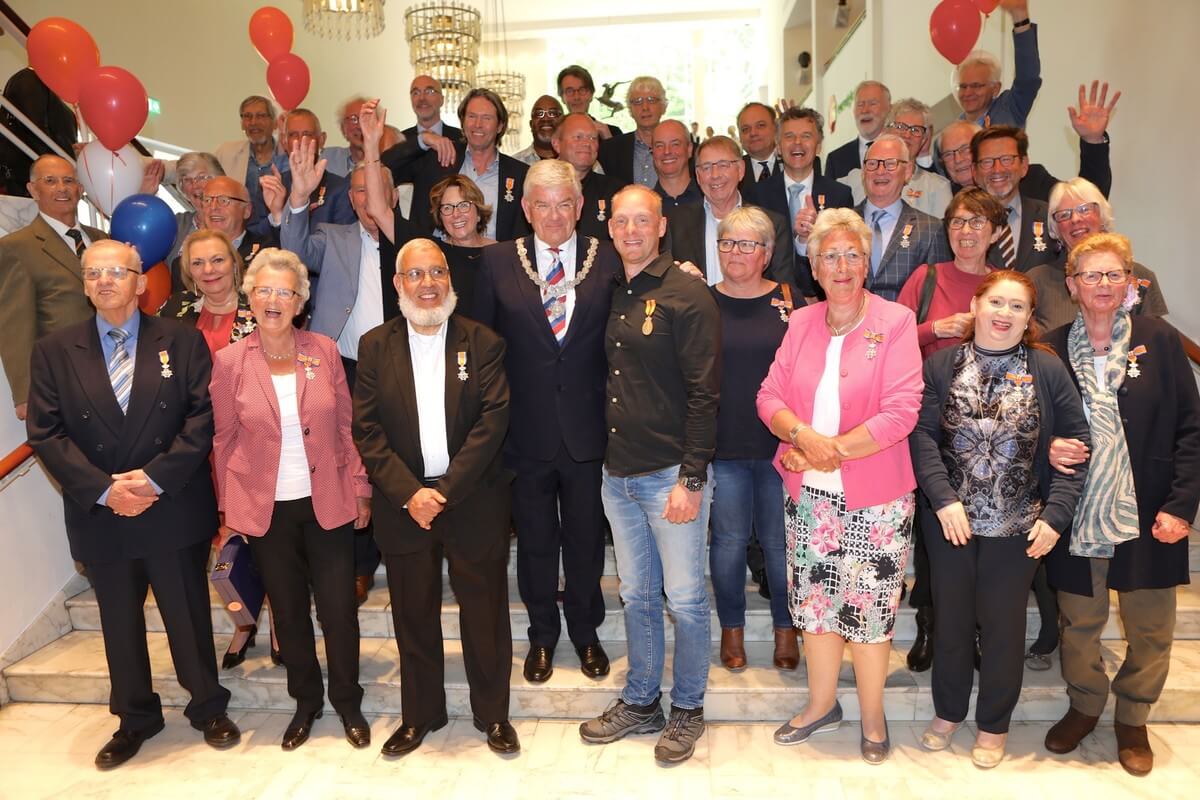 De 36 gedecoreerden met burgemeester Van Zanen op de trappen in de Stadsschouwburg. Foto's: Ton van den Berg