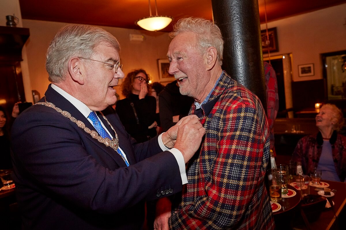 Burgemeester Jan van Zanen steekt de ‘Speld van de stad Utrecht’ op het revers van Dick Franssen.Foto: Humphrey Daniels