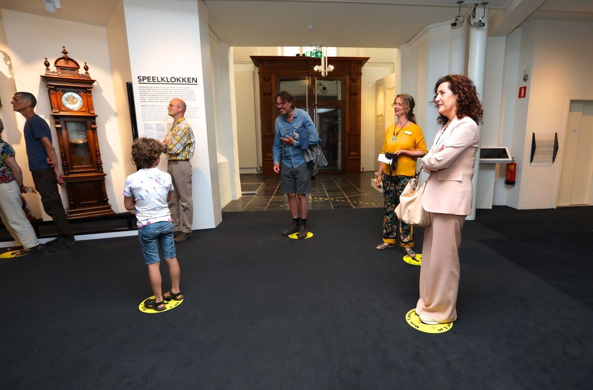 Minister Van Engelshoven (rechts vooraan) netjes op de aangewezen sticker volgt een rondleiding in Museum Speelklok. Foto: Ton van den Berg
