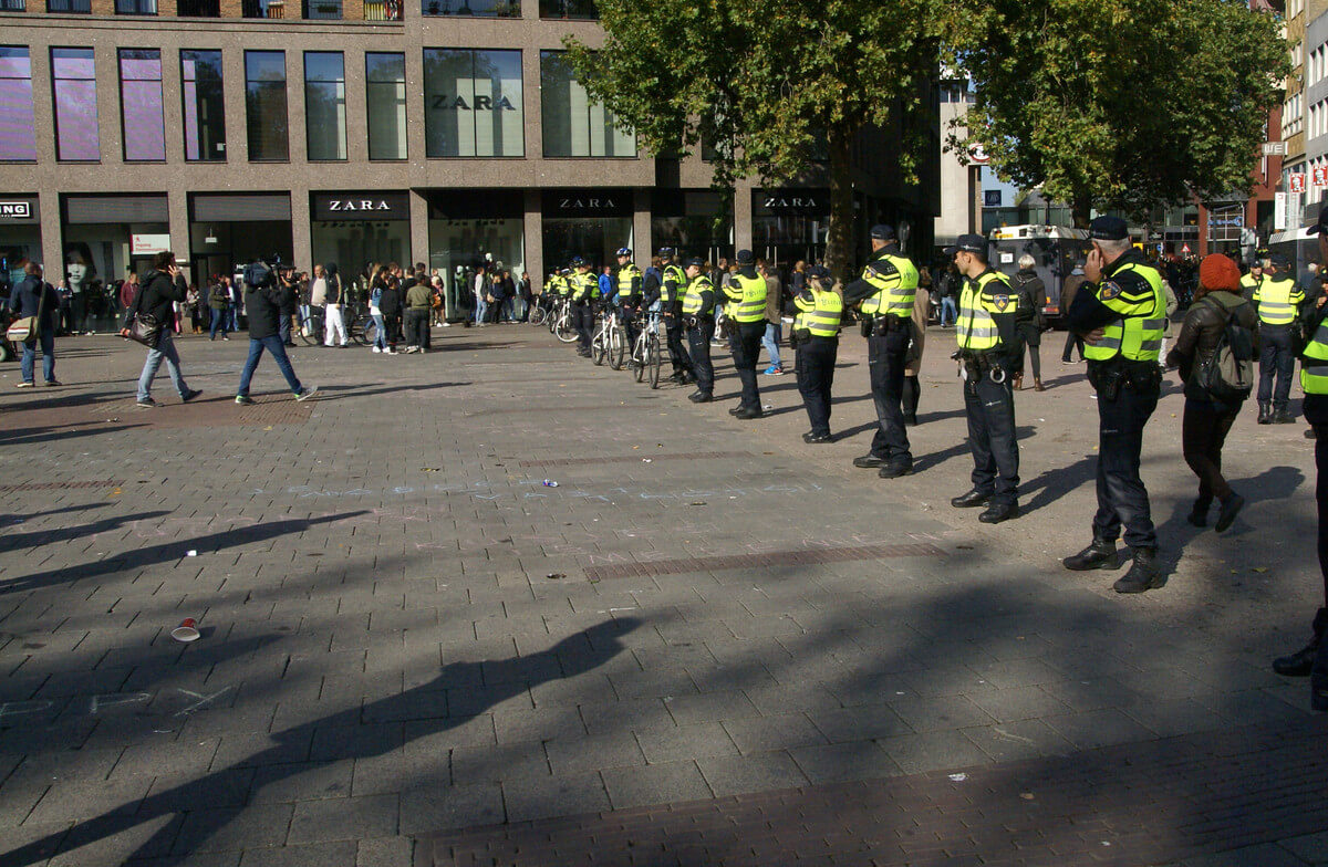 Politieagenten vormen een buffer tussen de partijen. Foto: Zita Eijzenbach